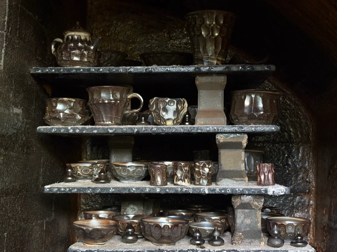 Ceramic vessels arranged on shelves inside a kiln